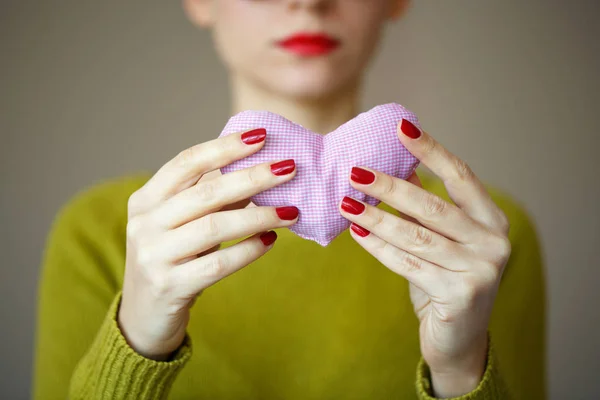 Cerca del corazón rosado en la mano de la mujer. Imagen del día de San Valentín — Foto de Stock