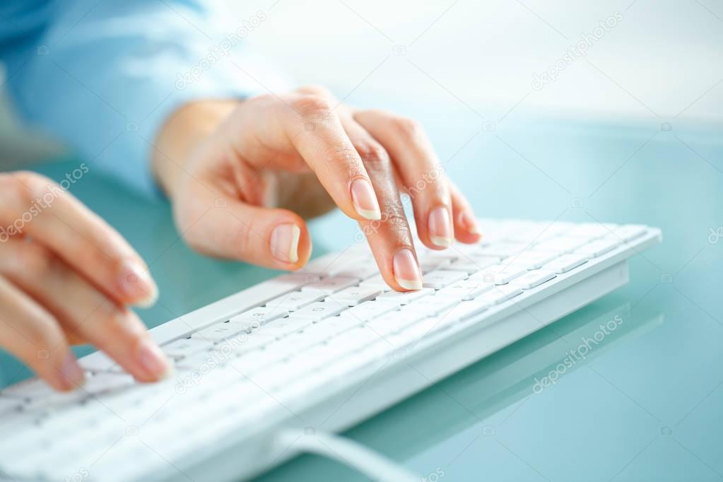 Woman office worker typing on the keyboard