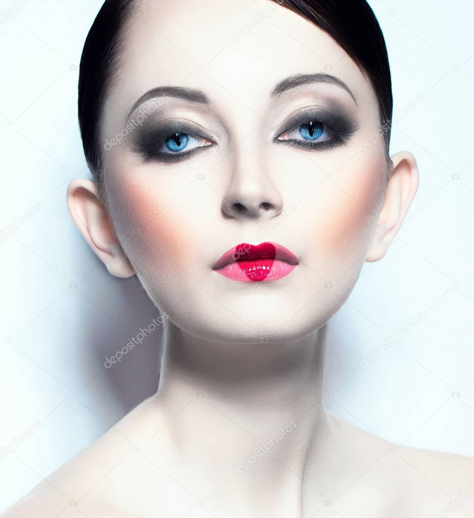 Beautiful young woman like doll with a glamorous cool makeup