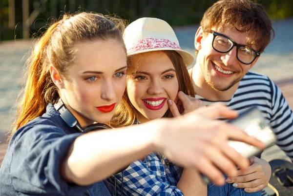 Sorrindo amigos fazendo selfie ao ar livre — Fotografia de Stock