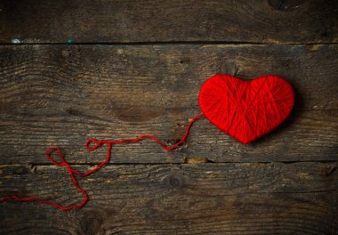 Yün eski püskü ahşap arka plan üzerinde yapılan kırmızı kalp şekli