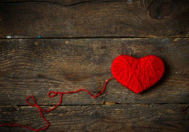 Yün eski püskü ahşap arka plan üzerinde yapılan kırmızı kalp şekli