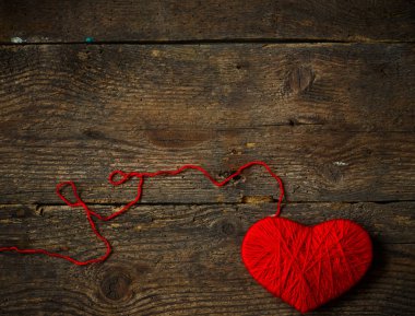 Yün eski püskü ahşap arka plan üzerinde yapılan kırmızı kalp şekli