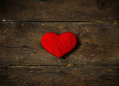 Yün eski püskü ahşap arka plan üzerinde yapılan kırmızı kalp şekli