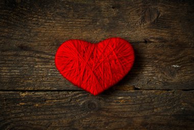 Yün eski püskü ahşap arka plan üzerinde yapılan kırmızı kalp şekli