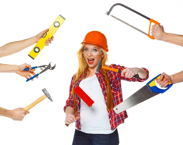 Funny girl in a helmet with different tools is isolated on the w — Stock Photo, Image
