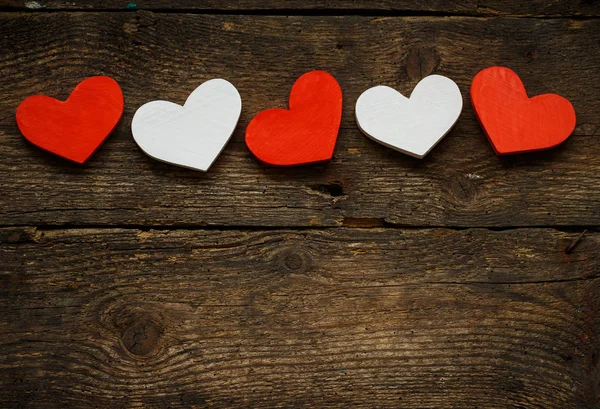 Röda och vita hjärtan på gamla trä bakgrund — Stockfoto