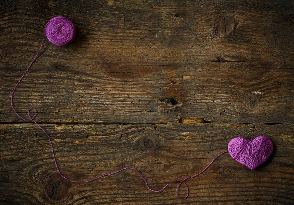 Purple Heart med en boll av tråd på på gamla shabby trä backg — Stockfoto