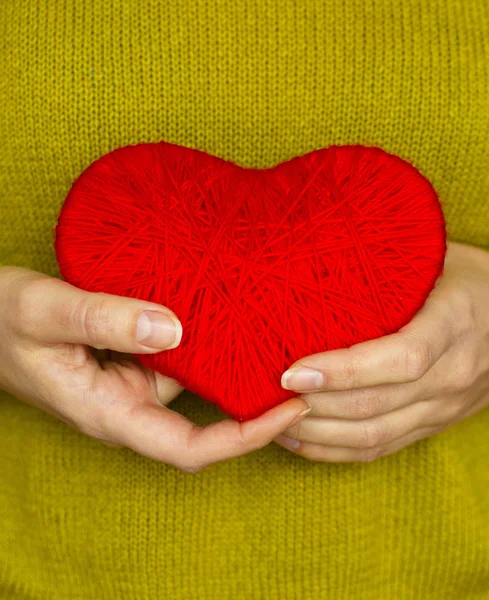 Detailní záběr na červené srdce z vlny v rukou ženy — Stock fotografie