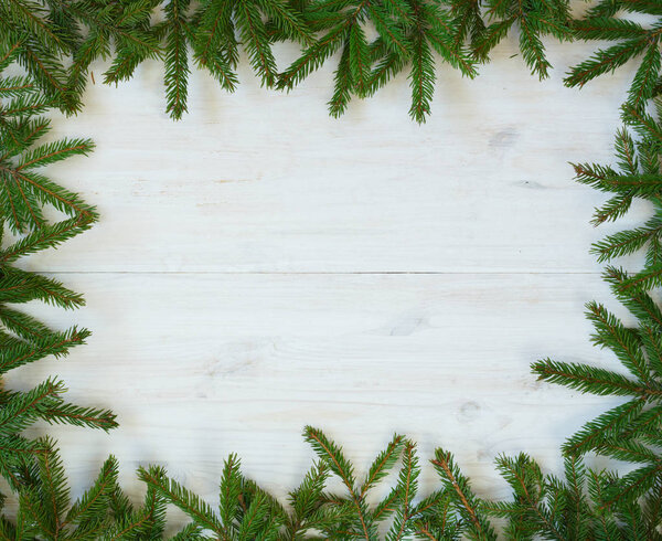 Christmas tree branches on white wooden texture ready for your d