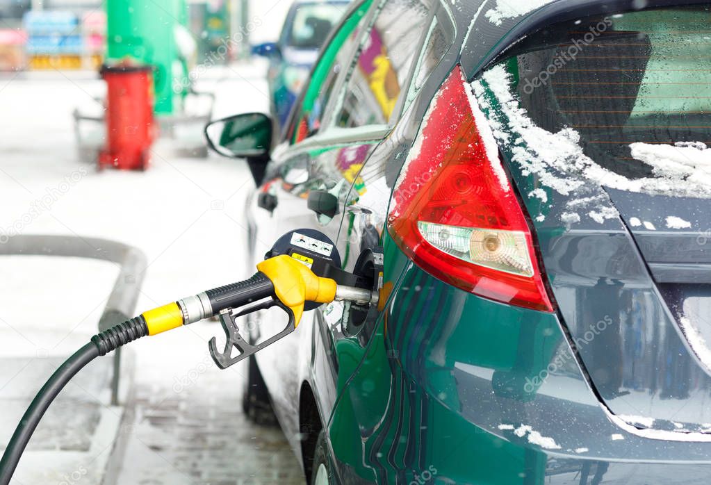 Car refueling on a petrol station in winter