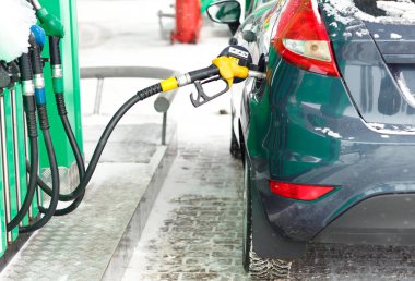 Bir benzin istasyonunda kışın yakıt ikmali araba