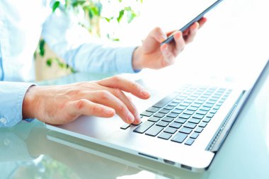 Klavyede yazarak ve smartphone kullanarak erkekler ofis çalışanı