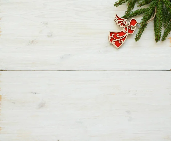 Tannenbaumzweige mit Weihnachtsschmuck auf weißem Holz — Stockfoto