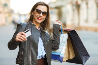 Güzel bir kadınla alışveriş torbaları ve kredi kartı elinde 