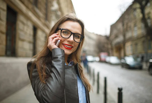 Mujer de negocios caminando por la calle mientras habla en pho inteligente — Foto de Stock