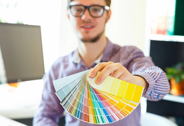 Young man looking to a color paint palette — Stock Photo, Image