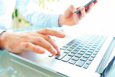 Klavyede yazarak ve smartphone kullanarak erkekler ofis çalışanı