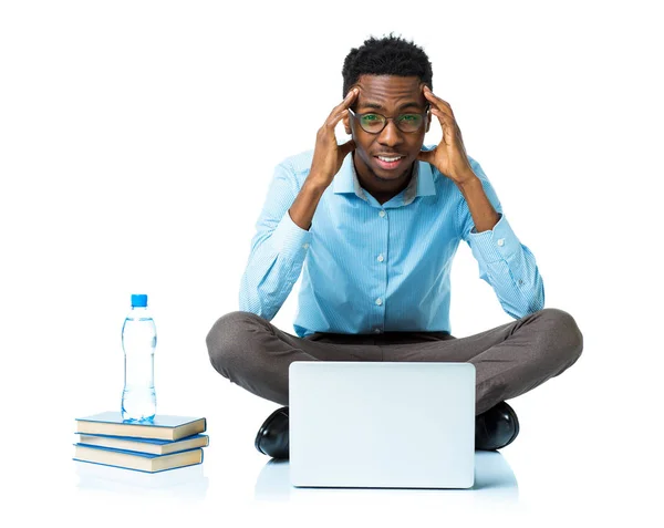 Africano americano estudiante universitario con dolor de cabeza sentado en blanco — Foto de Stock