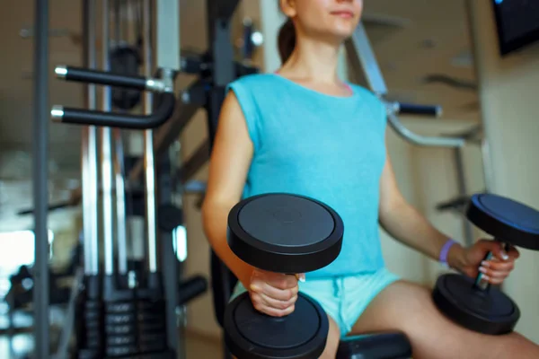Kadın egzersizleri yapıyor spor salonunda dumbbells ile — Stok fotoğraf
