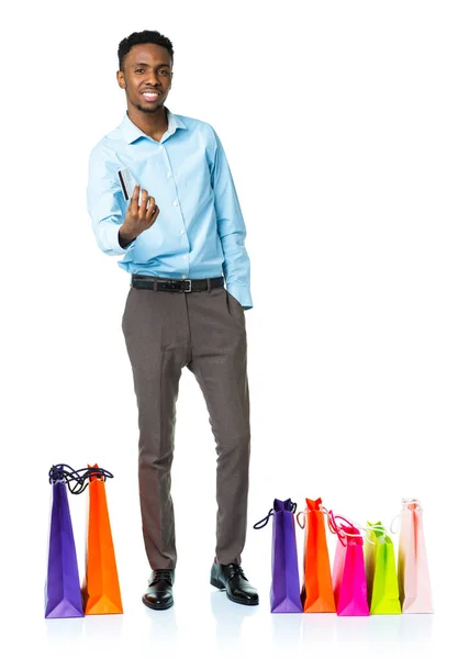 Homem americano africano feliz com sacos de compras e segurando credi — Fotografia de Stock