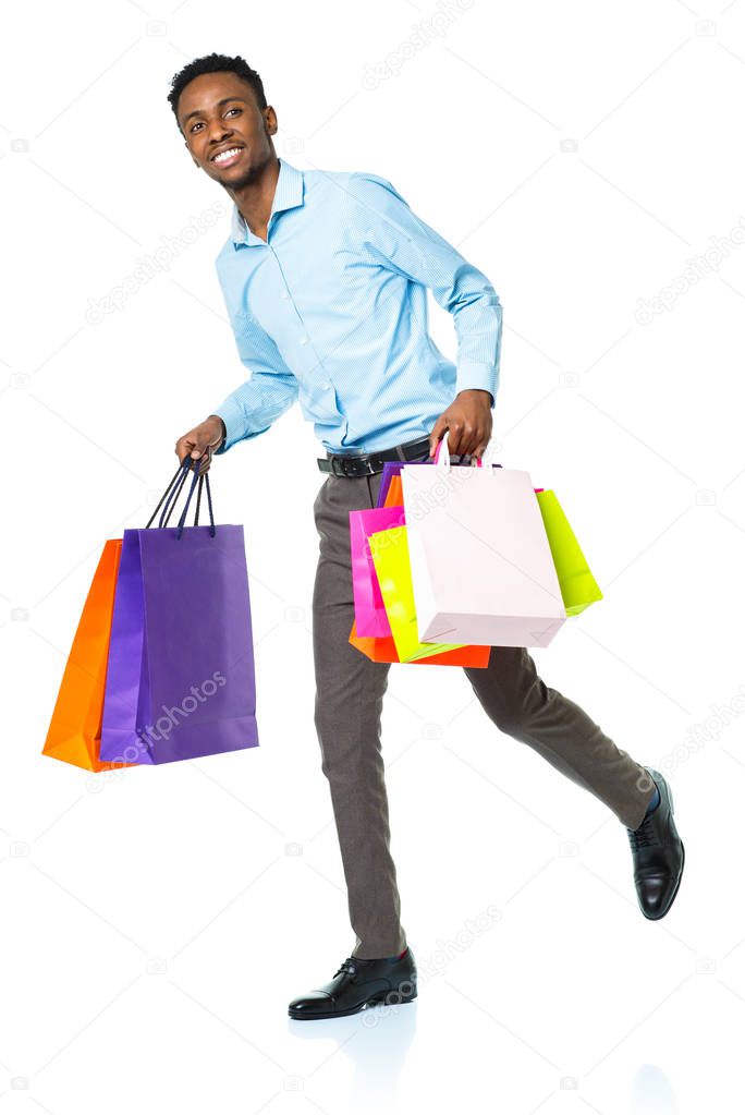 Happy african american man holding shopping bags on white backgr