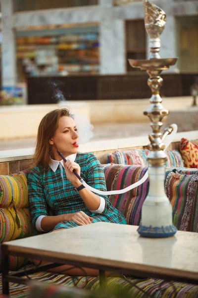 Güzel genç kadın bir kafede nargile sigara içiyor. — Stok fotoğraf