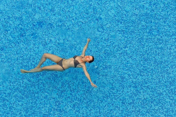 Wanita muda yang santai di kolam renang — Stok Foto