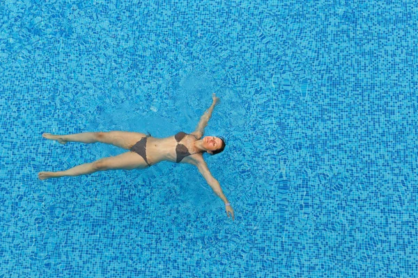 Wanita muda yang santai di kolam renang — Stok Foto