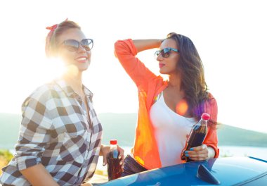 İki genç kız açık havada cabriolet eğleniyor