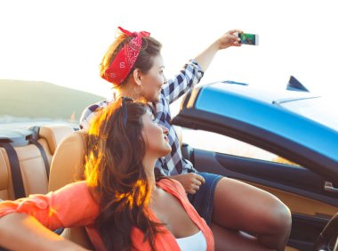 İki genç güzel kız selfie üstü açık bir araba içinde yapıyorsun