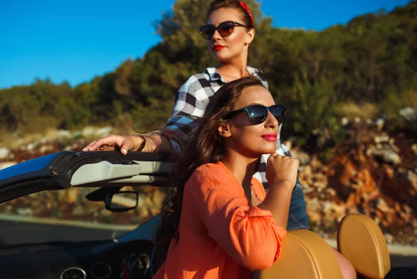 Dos chicas jóvenes divirtiéndose en el cabriolet al aire libre —  Fotos de Stock