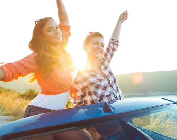 Dos chicas jóvenes divirtiéndose en el cabriolet al aire libre — Foto de Stock
