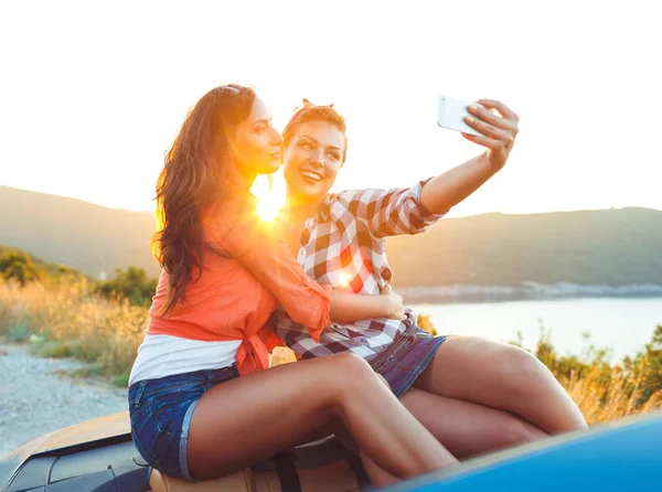 Δύο μικρά όμορφα κορίτσια κάνουν selfie σε μετατρέψιμο — Φωτογραφία Αρχείου