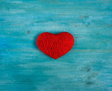 Yün mavi ahşap zemin üzerine yapılmış kırmızı kalp şekli
