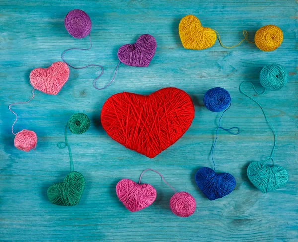 Mavi ahşap backgr iş parçacığında bir topları ile çok renkli Kalpler — Stok fotoğraf