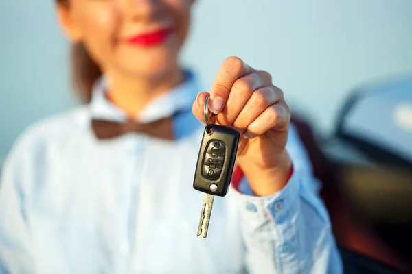 Mujer joven de pie cerca de un convertible con llaves en la mano —  Fotos de Stock