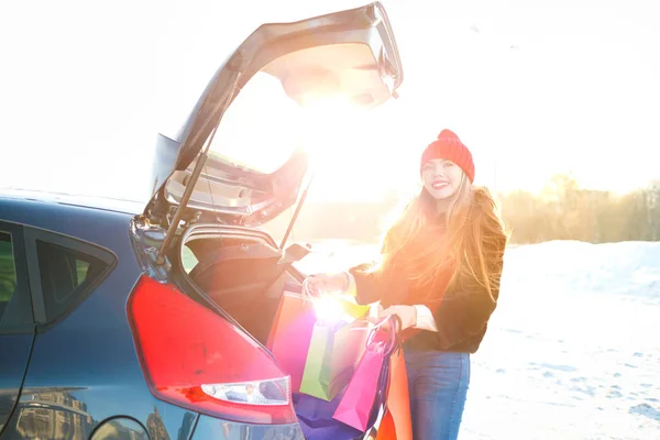 Lachende Kaukasische vrouw haar boodschappentassen ingebruikneming de auto t — Stockfoto