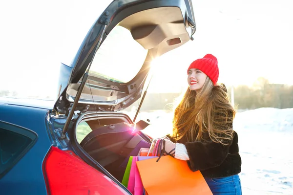 Souriant femme caucasienne mettre ses sacs à provisions dans la voiture t — Photo