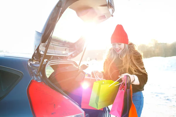 Beyaz bir kadın onun alışveriş torbaları araba t koyarak gülümseyen — Stok fotoğraf