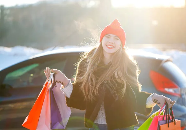 Lächelnde Kaukasierin mit ihrer Einkaufstasche neben dem Auto — Stockfoto