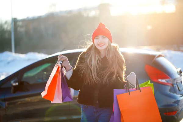 Souriant femme caucasienne tenant son sac à provisions près de la voiture — Photo