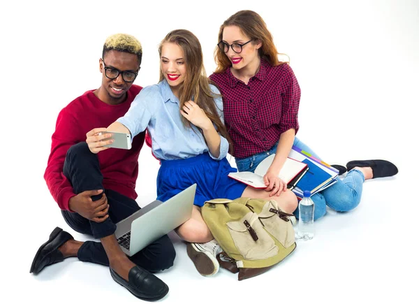 Tre studenti felici con libri, laptop, borse e fa selfie — Foto Stock