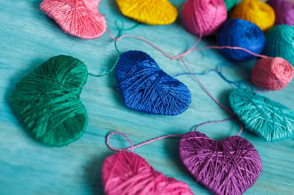 Multicolored Hearts with a balls of thread on blue wooden backgr — Stock Photo, Image