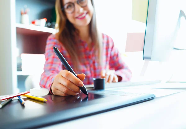 Grafikdesignerin zeichnet bei der Arbeit etwas auf Grafik-Tablet — Stockfoto