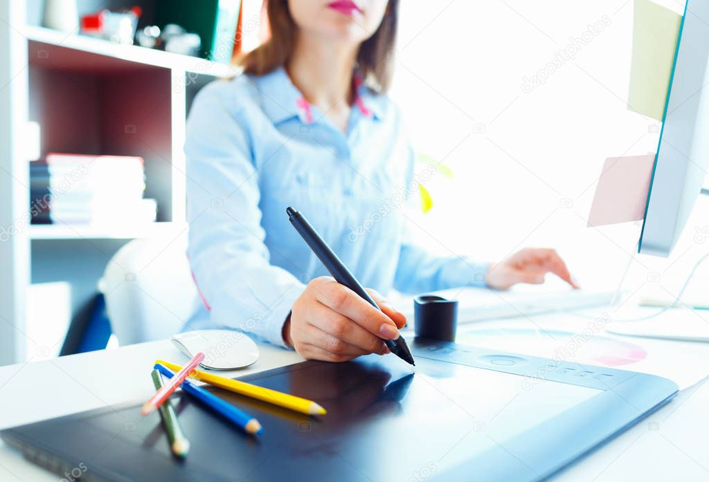 Graphic designer drawing something on graphic tablet at the home