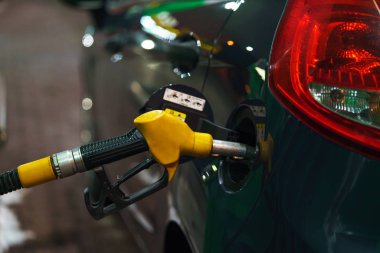 Bir benzin istasyonunda kış geceleri yakıt ikmali araba