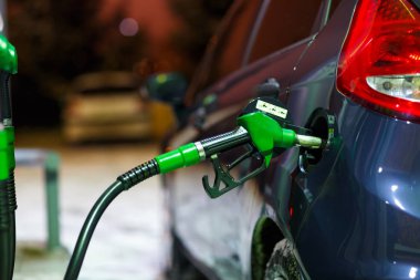 Bir benzin istasyonunda kış geceleri yakıt ikmali araba