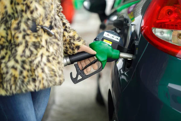 女性は冬にガソリン スタンドで彼女の車にガソリンをいっぱい — ストック写真