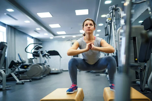 Mujer en el gimnasio haciendo ejercicios deportivos — Foto de Stock